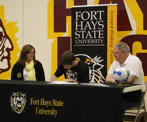 Senior Kellen Griffin signs his National Letter of Intent as his parents look on.