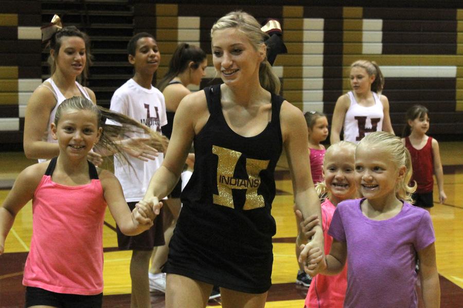 Junior Kali Pitcock dances with two young girls at the Youth Cheer Camp on Saturday morning.