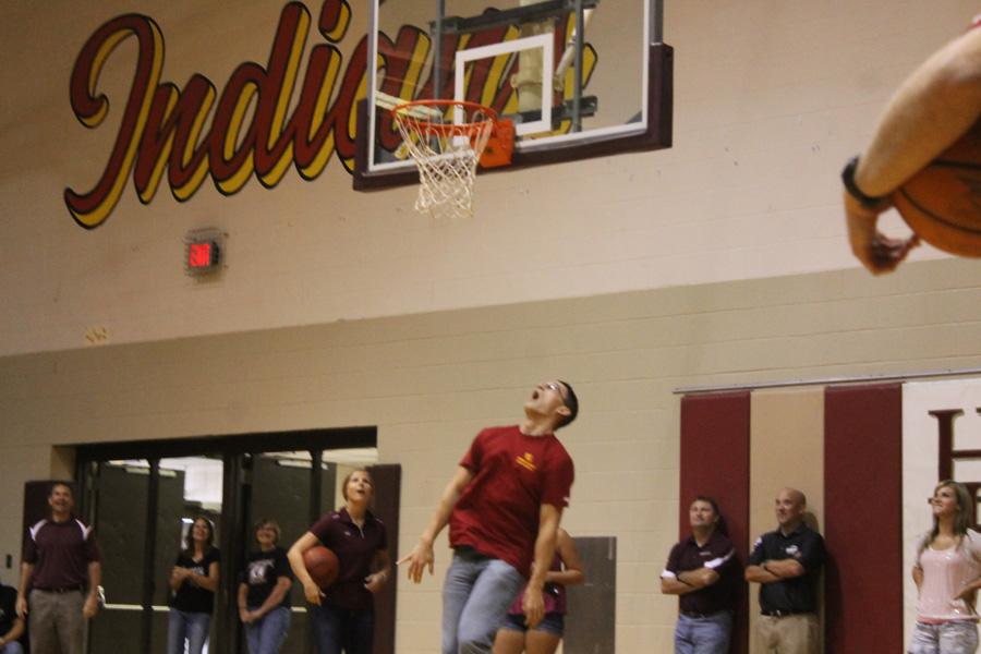 Teacher Jerett Pfannenstiel reacts to his shot as students and staff look on.