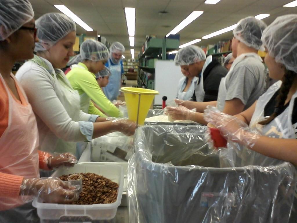 Volunteers work an assembly line to package a meal at FHSUs Forsyth Library.