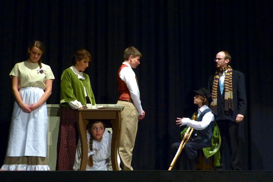 In this scene from Hays Community Theatres A Christmas Carol, the Cratchit family welcomes home their father Bob and brother Tiny Tim. 