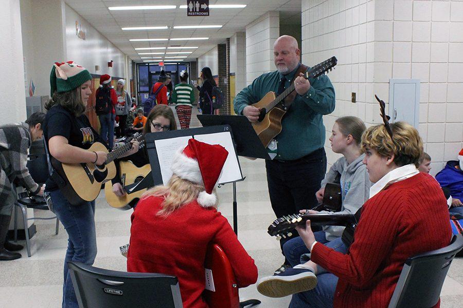 The guitar club performs in the freshman hallway before first hour. 