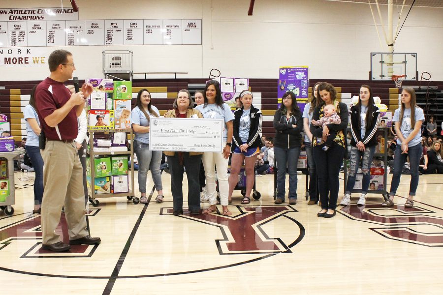 Instructor Sue Ann Tebo and her family studies students are introduced by principal Martin Straub. The class presented Ellis County First Call for Help with a contribution of over 7,000 diapers. 