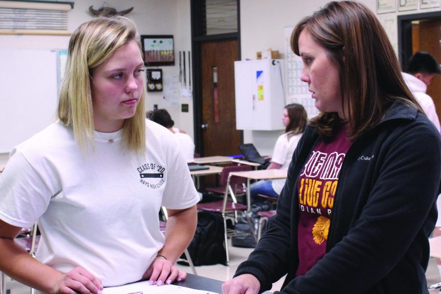 Instructor Beth Schiel helps student Macee Altman with an assignment during Honors Biology. 