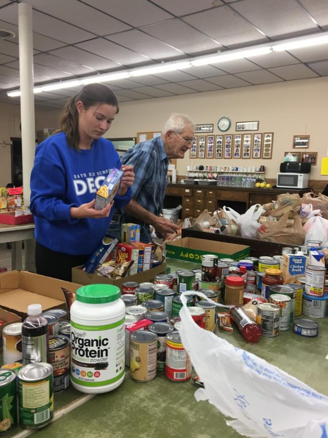 Senior Lisa Schoenberger marks the labels on the cans so they cannot be returned. Every can was counted and then sent to have that done.