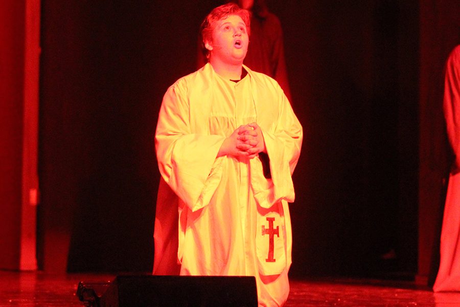 Father Claude Frollo (senior Eric Adams) sings of his love for Esmeralda (senior Erin Muirhead) and asks why he has fallen for her. He believes that her soul is unclean and in need of saving, yet he still loves her. He asks for God to either give Esmeralda to him or for her to burn in hell (Hellfire).