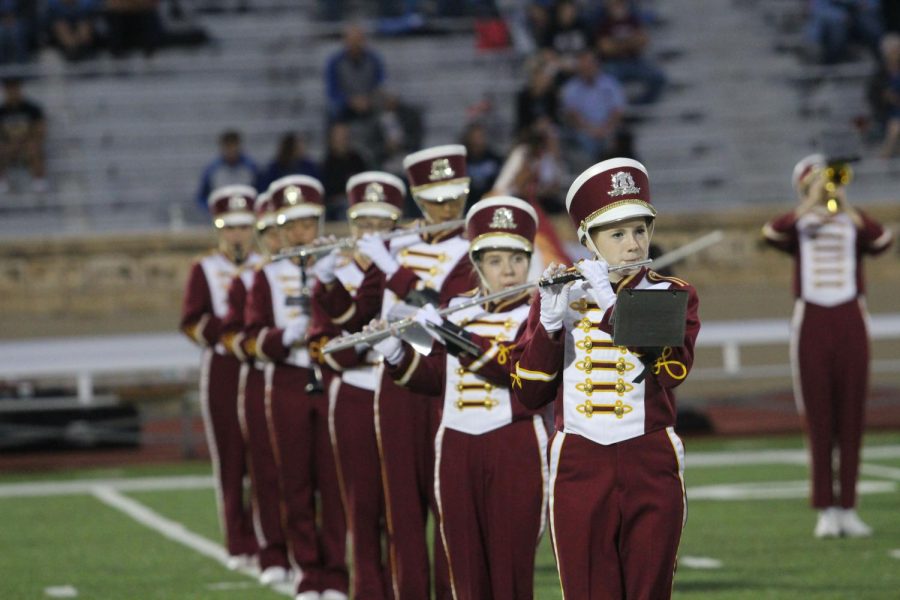 The marching band plays during a football game during halftime. Two students took first chair during district band.