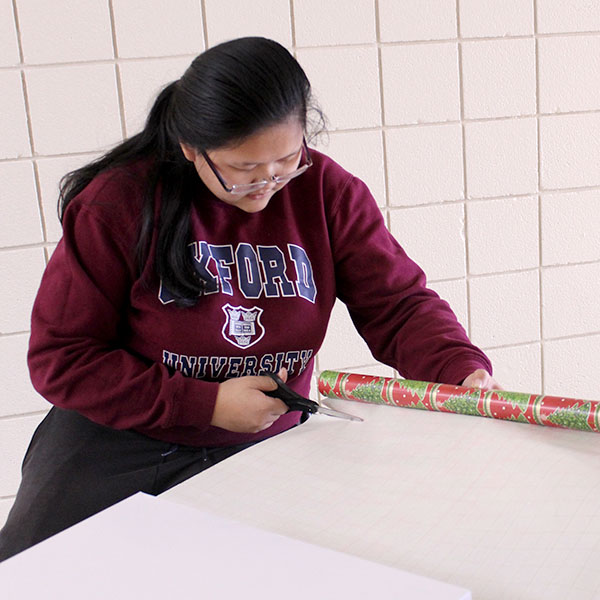 Senior Lucy Lin cuts wrapping paper.