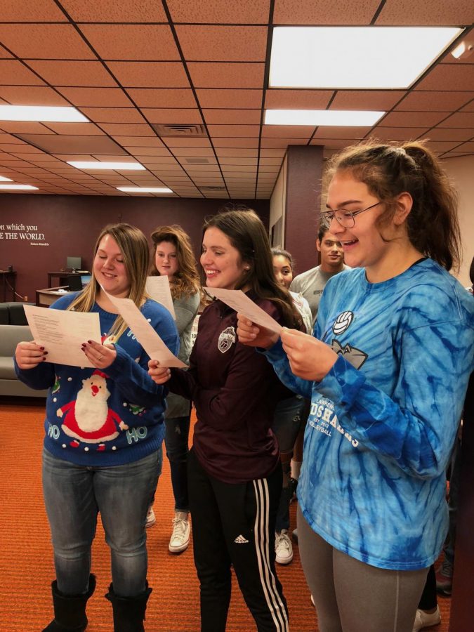 Juniors+Lindsey+Pfannenstiel%2C+Hannah+McGuire+and+Jaysa+Wichers+carol+in+the+library+during+G2.+This+is+their+second+year+caroling.