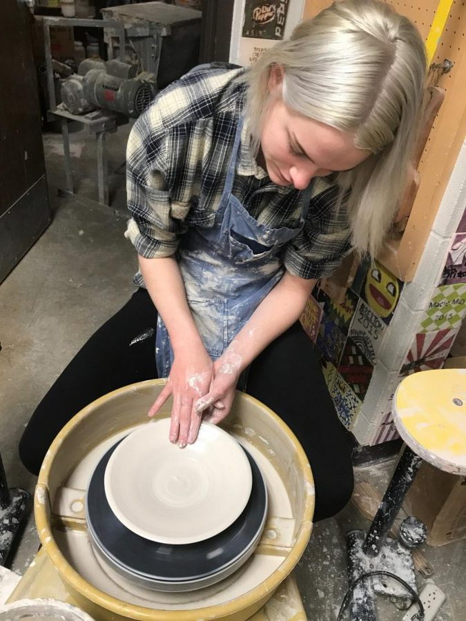 Senior Mikayla Koerner sits at her wheel to make a plate. 
