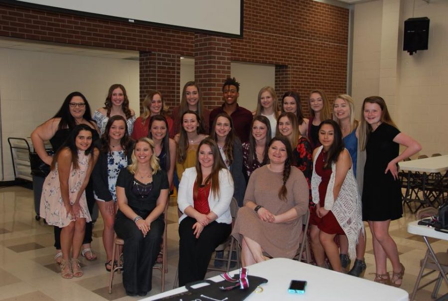 Members of the cheer team pose for a picture with their coaches during the banquet. The banquet was held in the cafeteria on March 13.
