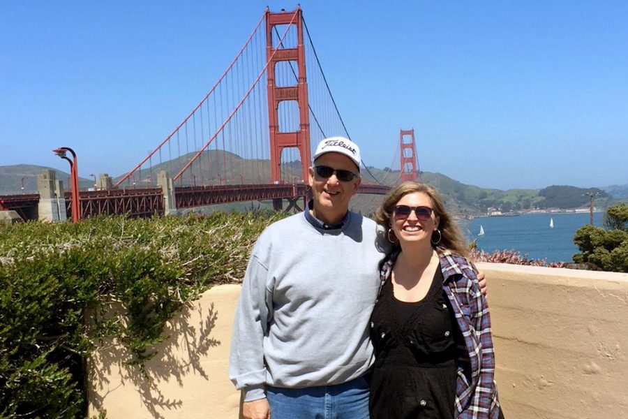 Hays High alumni Delphine Burns poses with journalism instructor Bill Gasper in front of the Golden Gate Bridge.