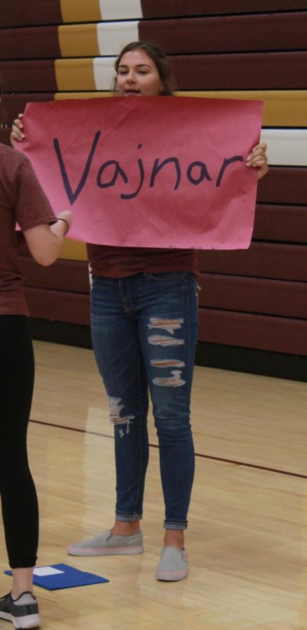 Senior Jaysa Wichers holds up a sign with her assigned academy to help the freshmen in her group find her. 
