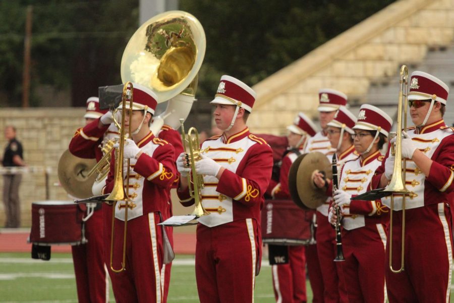 The marching band performs at a home football game. Overall, they received a II rating at contest.