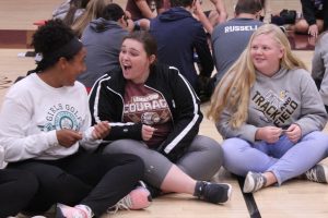 Freshman Taleia McCrae, senior Hannah Harman and freshman Katie Tinkel participate in the Wright Family Activity. The object of the activity was to move a paper clip left and right every time they heard Wright and left.