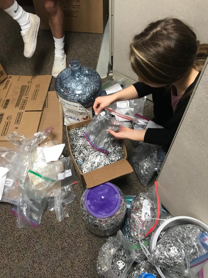 Senior Isabelle Braun sorts pull tabs that were collected from the middle school contest.