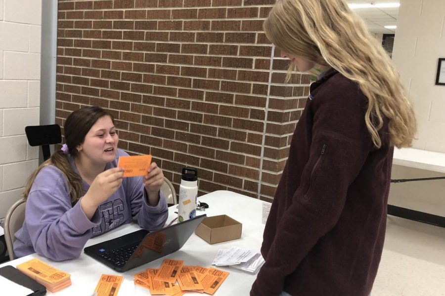 Senior Shyann Schumacher works to sell coupon books at the parent-teacher conferences on Nov. 29. The coupon books raise money for the Ronald McDonald House Charities which allow families with severely ill children to stay for low to no cost. 