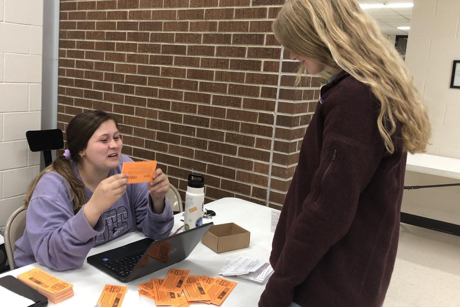 Senior Shyann Schumacher works to sell coupon books at the parent-teacher conferences on Nov. 29. The coupon books raise money for the Ronald McDonald House Charities which allow families with severely ill children to stay for low to no cost.