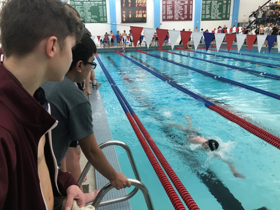 Hays swimmers watch as senior Brett Bowles completes his last 50 yards in the 200 Individual Medley.