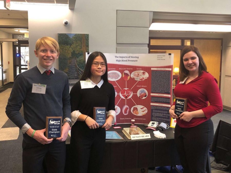 Senior Johnny Fuller and sophomores Ginny Ke and Callie Raacke with their project and award. The three will now have their presentation displayed during the Kansas Idea Network of Biomedical Research Excellence (K-INBRE) Symposium.