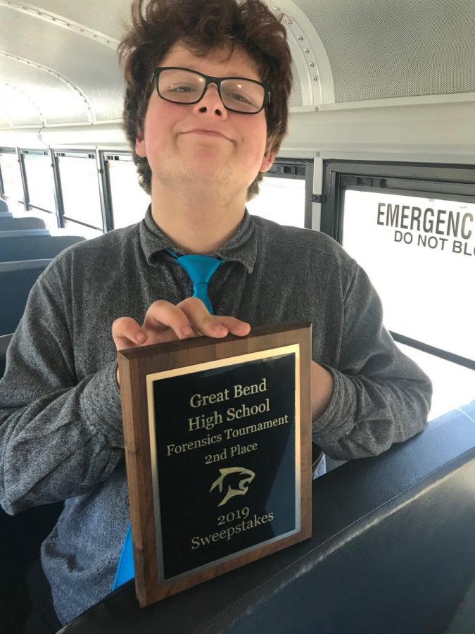 Senior Neil Raynesford poses with the second place plaque from the forensics tournament at Great Bend on March 30.