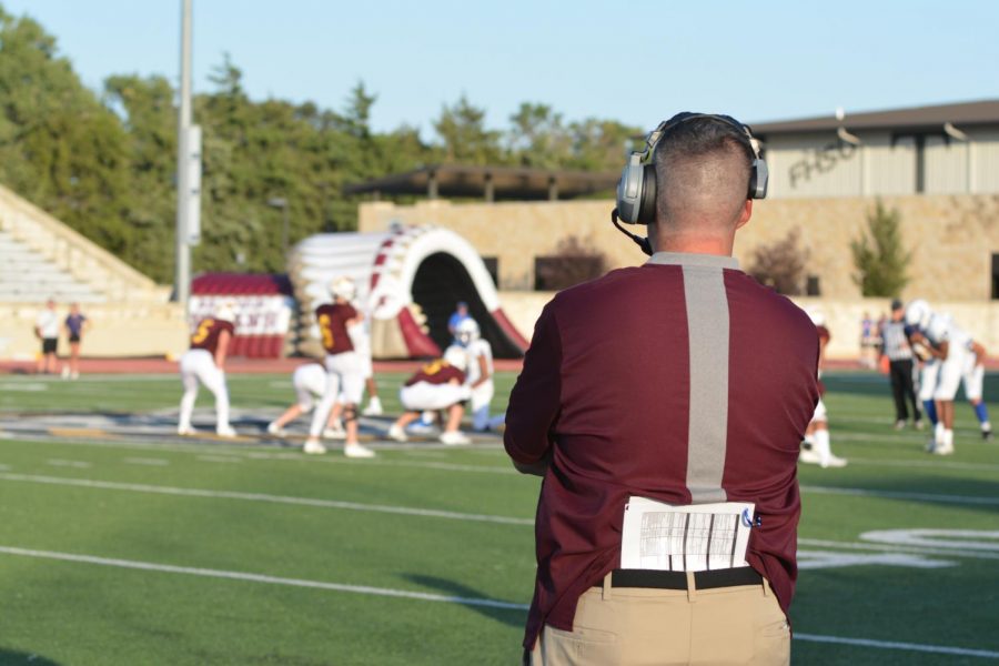 Coach Tony Crough watches from the sideline as the Indians run an offensive play.