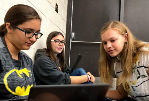 Senior Sierra Adkins, junior Alexis White and sophomore Samantha Vesper watch a promotional video for a disaster relief charity during the research time in Chamber Singers. This years featured organization is All Hands and Hearts.