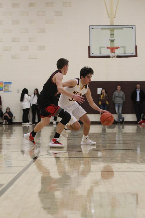 Sophomore Ashton Hernandez dribbles the ball around an opponent during the home game against Great Bend on Jan. 14. 