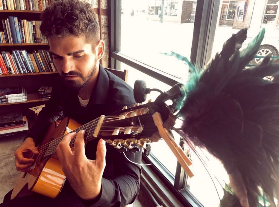Artist, writer and classical guitarist Joshua Merello performs in The Dusty Bookshelf book store in Manhattan, Kan. Merello, who had played guitar as a hobby in and out of different bands, began taking music seriously at the beginning of 2018 when his father was diagnosed with terminal cancer. The family struggled to express their emotions in words, but through playing guitar for his parents during that time, Merello found he was able to pour both his joys and struggles into his music.
