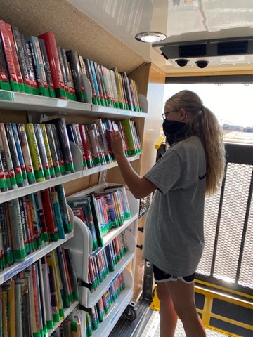 Sophomore Michaela Dickman sorting through the large display of books inside the Bookmobile.