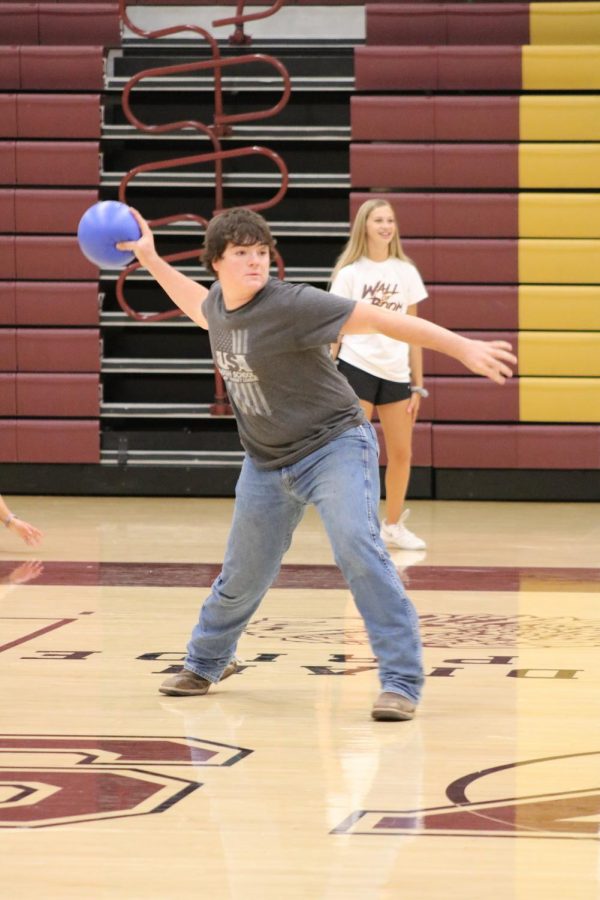 Junior Gage May throws a dodgeball during the team building activity.