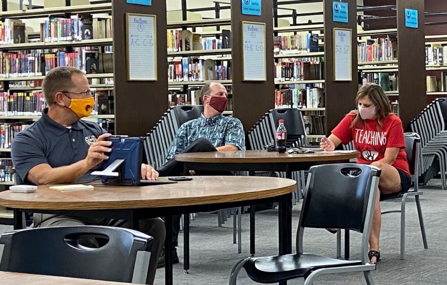 From left to right, principal Martin Straub, Joe Lohmeyer and Misty Lohmeyer sit in the library during the Site Council meeting. Misty Lohmeyer was instated as the Site Council president during the meeting.