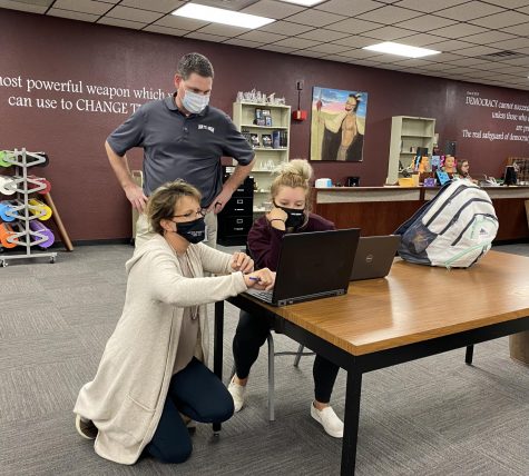 Counselors Troy Dale and Amy Miller help senior Sierra Smith fill out her college application.