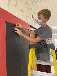 Junior Ryan Schuckman decorates the junior hallway.