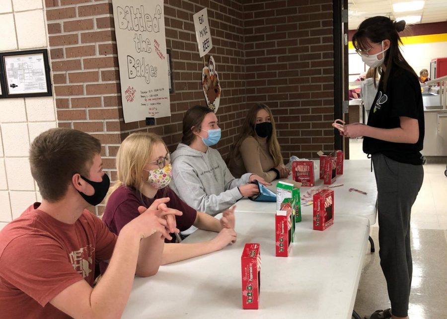 Junior Class Co-Vice-President Tyler Solida and StuCo members Jocelyn Rigler, Sydney Wittkorn, and Hayli Meier sell candy canes to sophomore Maysyn Tippy.