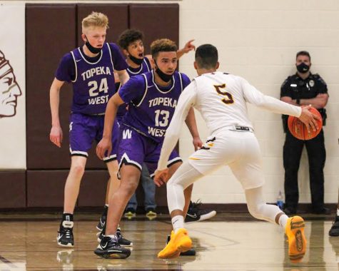 Senior Tj Nunnery dribbles the ball near a Topeka West deffender on March 9th. 