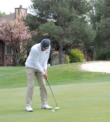 Sophomore Braden Hoskin takes a practice putt on the green of hole number nine at Smoky Hill Golf Course.