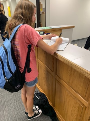 Senior Alexandra Coveney checks out of the building during her Career Exploration hour. 