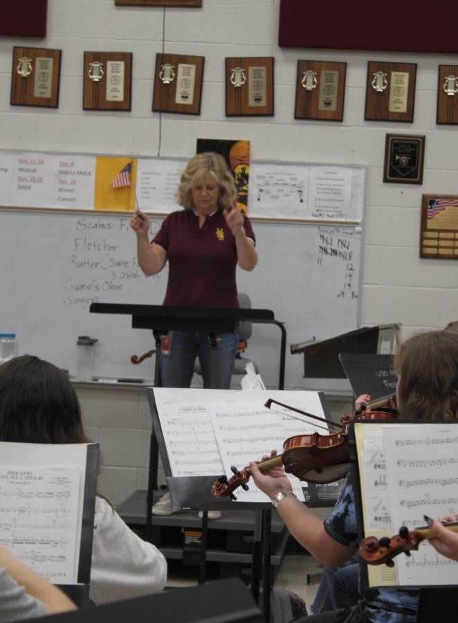Orchestra+teacher+Joan+Crull+conducts+the+HHS+orchestra+at+one+of+their+practices.