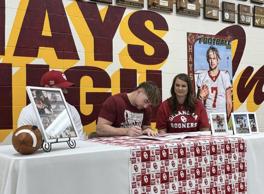 Senior+Jaren+Kanak+signs+to+the+University+of+Oklahoma+with+his+family+in+the+HHS+Cafeteria+during+Pride+Time.