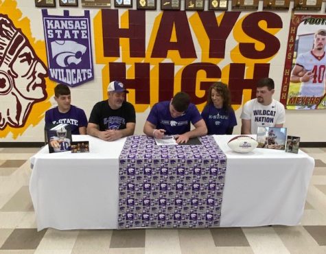Senior Gavin Meyers signs a letter of intent to play football for Kansas State University on Mar. 22 in the HHS cafeteria.