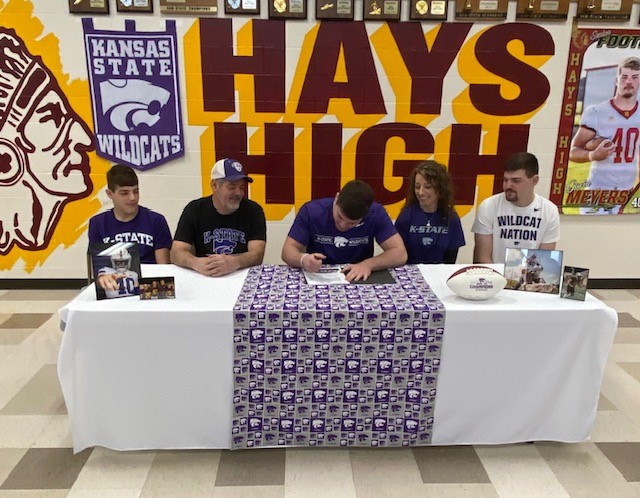 Senior+Gavin+Meyers+signs+a+letter+of+intent+to+play+football+for+Kansas+State+University+on+Mar.+22+in+the+HHS+cafeteria.