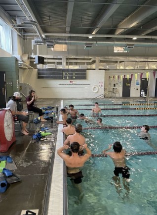 Boys swimming coach Jane Rorstrom instructs the team members about their workouts for practice on Dec. 8. The team members already completed their warm-ups for the day. “I’ve been involved in swim since roughly 1979,” Rorstrom said. 