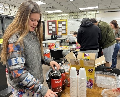 Freshman Mia Schlegel gets a cup for her drink on Dec. 9 in her PRIDE Time teacher Jessica Augustine's classroom. Each student brought a food or drink to share with the class, such as chips and dips, cookies and s'mores brownies. "The PRIDE Time party put me in the Christmas spirit," Schlegel said.