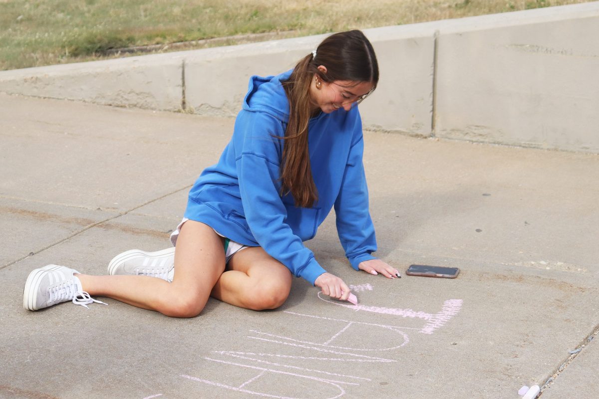 Sophomore Riley Larkins writes out Jana's Campaign. This event was for Domestic Violence Awareness Month. 