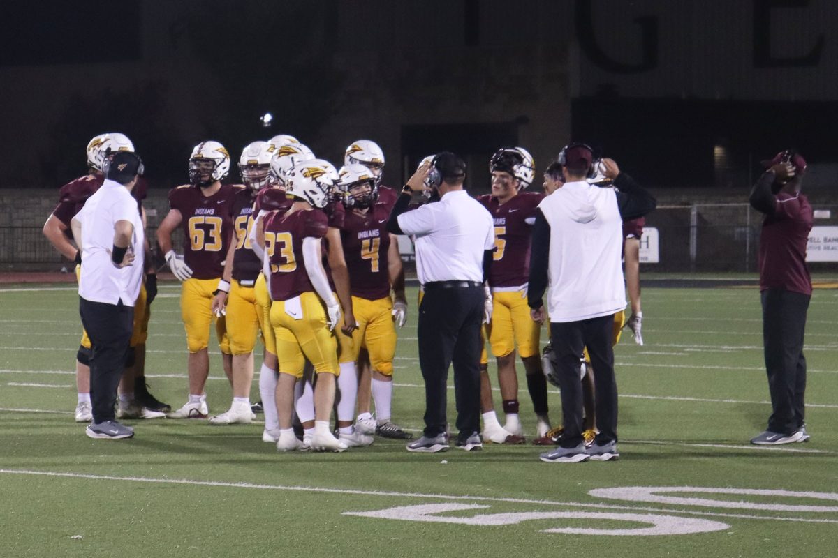 The Hays High offense gathers in the huddle during a timeout against Dodge City.