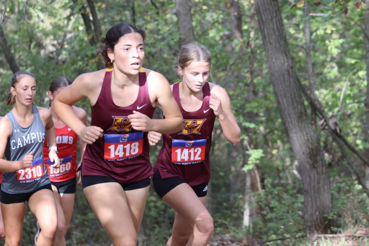 Juniors Ava Biggs and Aralen Maupen race up a hill at the race in Lawrence. 