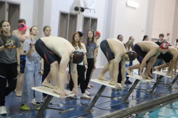 Racers in the boys swim meet in Hays prepare to dive in their race.