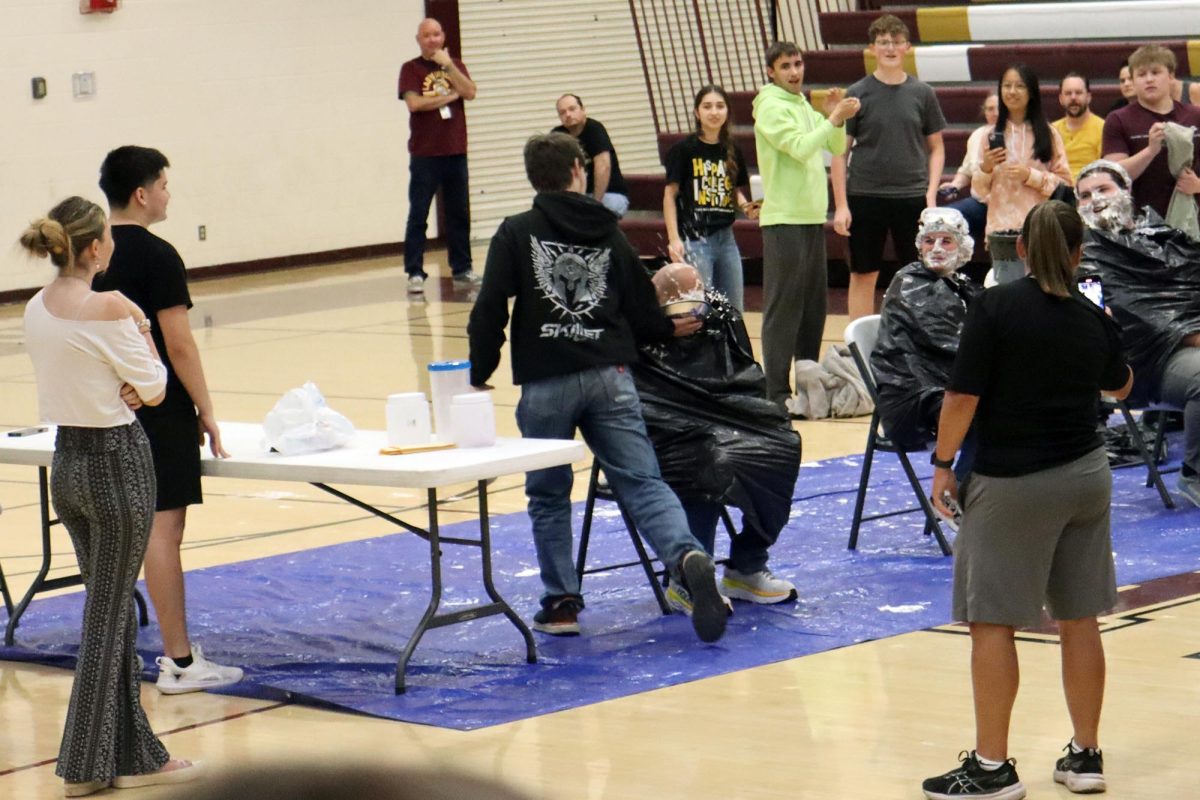On Friday, May 16, teacher Matt Brooks get "pied" in the face by a student at a fundraiser assembly for the debate team.