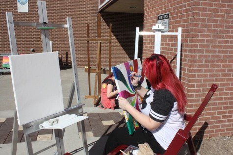 Art students paint outside during nice weather